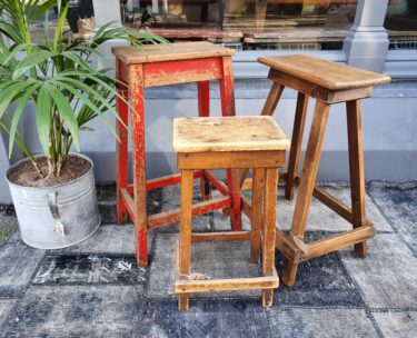 three wooden stools seating stools